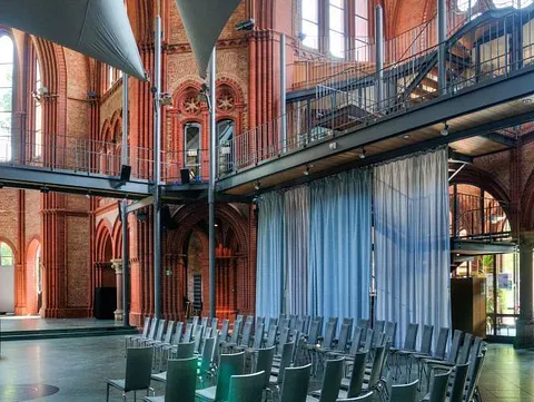 Innenansicht eines Kirchensaals mit Stühlen und modernem Design.